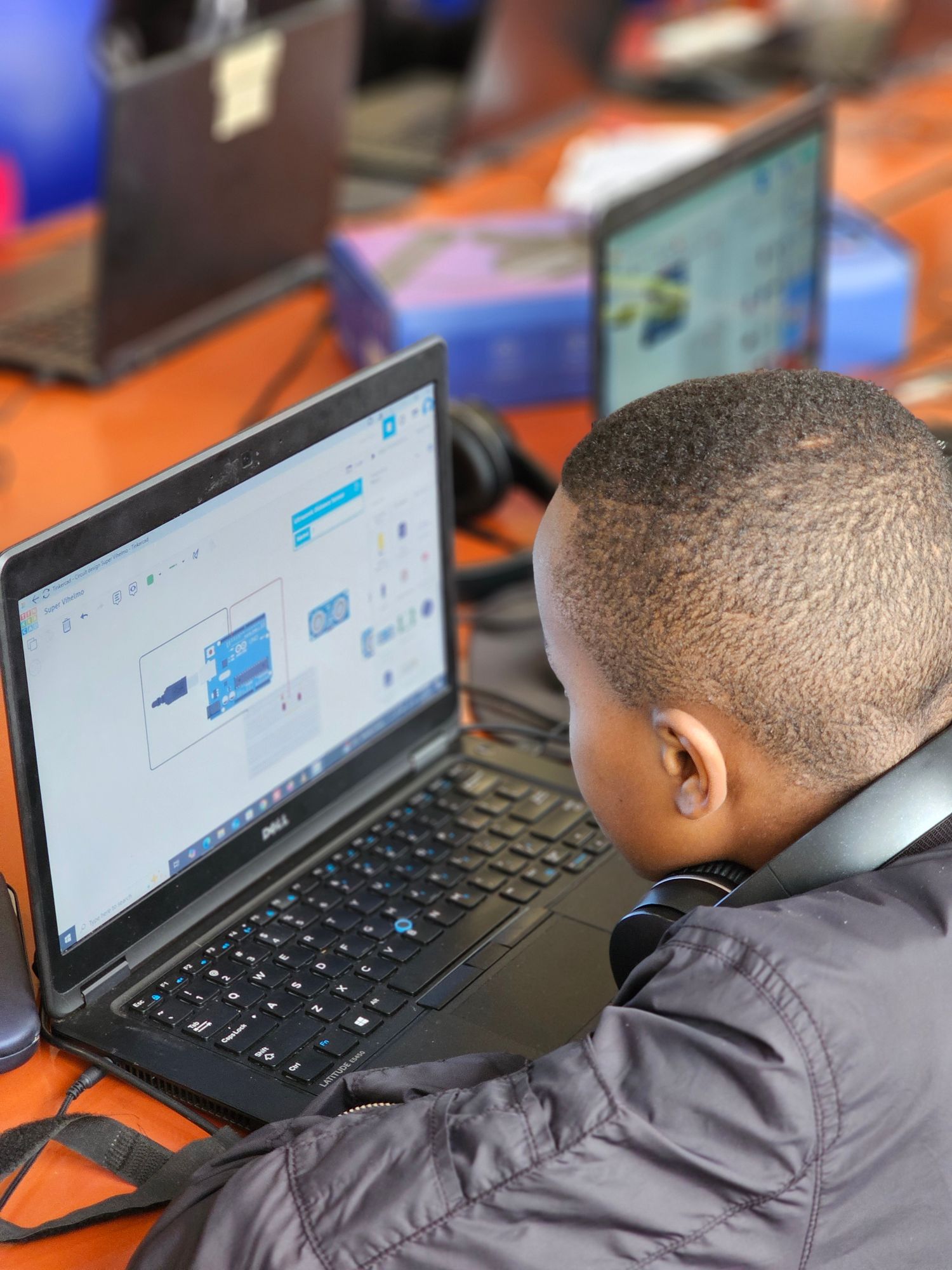 A student designing a circuit in Tinkercad on a laptop